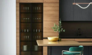 A beautiful kitchen boasting wood and black paneled cabinetry, an opulent golden bowl and accompanying vase with foliage