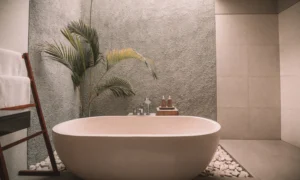 A modern, earth-toned oasis of a bathroom, with a luxurious tub surrounded by white river stones